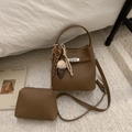Détail d'un sac seau marron en cuir grainé avec boucle argentée et breloque peluche - Marron avec Pendentif