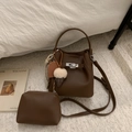 Détail du sac seau marron foncé en cuir grainé avec fermoir rotatif argenté - Café Avec Pendentif