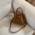Dettaglio di una borsa tote in pelle marrone con fibbia e ciondolo a coniglietto - Marrone con Ciondolo