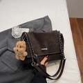 Detail of vintage brown suede shoulder bag with gold chain and plush bear charm accessory - With Pendant / Coffee