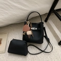 Détail du sac seau noir en cuir grainé avec fermoir argenté et breloque en forme de cœur - Noir Avec Pendentif