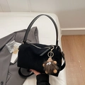 Detail of black suede Boston bag featuring a playful brown fur monster charm on the zipper - Black With Pendant