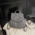 Detail of grey waffle fabric backpack featuring white letter embroidery and drawstring closure - Gray