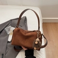 Detail of vintage brown suede pillow bag with plush ball charm and smooth leather handle - Brown with Pendant