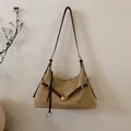 Detail van de kaki suède schoudertas met gekruiste riemen en gouden metalen accessoires - Khaki