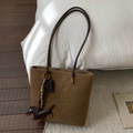 Detailed macro view of brown frosted suede tote bag featuring a cute dachshund leather charm - Brown with Pendant