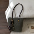 Retro dark green matte tote bag with shoulder straps and dog charm on a soft bed - Green with Charm