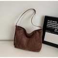 Primer plano de un bolso tote de ante marrón oscuro con elegantes costuras blancas - café
