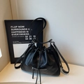 Detalle de bolso tipo cubo acolchado negro con cremallera plateada y cierre de cordón - Negro