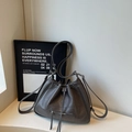Primer plano detallado del bolso de cubo en cuero acolchado gris oscuro con cordón y cremallera - Gris