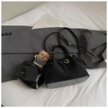 Detalle del bolso tote de ante negro con colgante de oso y hebillas de diseño estructurado - Negro Con Colgante