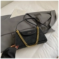Sac bandoulière chic en velours mat noir avec chaîne dorée sur un fond de veste blazer - Noir