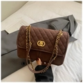 Dettaglio della borsa shopper vintage in camoscio marrone con catena oro e chiusura tonda - Caffè Opaco
