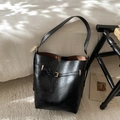 Detail einer schwarzen Beuteltasche aus Leder mit Vintage-Textur und Goldschnalle - Schwarz