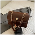 Detailed close-up of dark brown glossy shoulder bag with gold chain and round clasp lock - Dark Brown