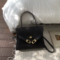 Detail of black leather briefcase bag with golden twist lock on white carpet - Brown