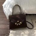 Detail of vintage dark brown faux suede handbag with elegant gold hardware on white fabric - Brown