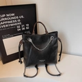 Detailansicht der schwarzen Beuteltasche mit Metallkette und elegantem Markenlogo-Aufdruck - Schwarz