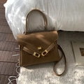 Close-up of vintage brown suede briefcase bag with elegant golden geometric clasp detail - Caramel color
