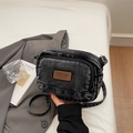 Detail of black washed denim crossbody bag featuring a leather logo patch and dual zippers - Black