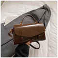 Detailed view of the dark brown leather Boston bag with retro bronze metal hardware accents - Brown