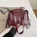 Burgundy faux leather handbag with wide eyelet strap and tassel details on both sides - Burgundy