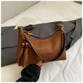 Detailed macro view of brown suede underarm bag with fringe charm and gold hardware - Coffee With Pendant