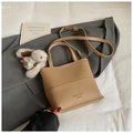 Detail of lychee pattern leather bucket bag with top handles and plush bunny charm - Khaki With Pendant