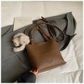 Detail of brown lychee grain leather bucket bag with plush rabbit charm decoration - Coffee With Charms