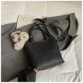 Detail of black pebbled leather bucket bag with brand embossing and rabbit plush charm - Black With Pendant