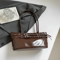 Primer plano del bolso de hombro en charol marrón con elegantes hebillas decorativas - Marrón