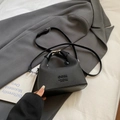 Chic black mini crossbody handbag with pebble leather texture and unique handle - Black Without Charm