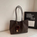 Detailed macro of dark brown matte tote bag with fuzzy charm on marble surface - With Pendant / Coffee