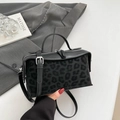 Detail der Handtasche aus schwarzem Leder mit Leopardenmuster und silbernen Beschlägen - Schwarzer Leopard