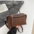 Detailansicht der dunkelbraunen Handtasche mit Leopardenmuster und silbernen Reißverschlüssen - Kaffee Leopard