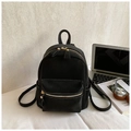 Detail eines schwarzen Mini-Rucksacks mit Kontrastnähten, Laptop und Freizeit-Zubehör - Schwarz