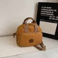 Detail van gembergele nylon schoudertas met zilveren hardware en dubbele handgrepen - Khaki