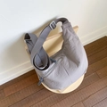 Top view of a grey nylon crescent tote bag on a wooden chair showing fabric texture - Gray
