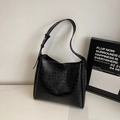 Dettaglio della texture in pelle nera a motivo coccodrillo sulla borsa a secchiello - Nero