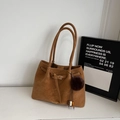Detail der Wildleder-Tote-Bag mit Ledergürtelschnalle und braunem Pelz-Anhänger - Braun mit Anhänger