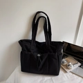 Detail of black quilted tote bag with drawstring pockets and lightweight nylon texture - Black