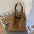 Macro shot of large brown suede tote bag texture and soft integrated handle design - Brown