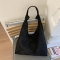 Detail of minimalist black suede tote bag showing soft matte texture and knotted handles - Black