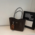 Dettaglio della texture della borsa tote in ecopelle marrone con logo e ciondolo orsetto - Caffè Con Ciondoli