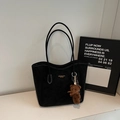 Dettaglio della borsa tote nera in camoscio con cuciture bianche e ciondolo a forma di orso - Nero Con Pendente