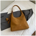 Détail du sac hobo en cuir caramel avec large bandoulière et petit logo imprimé - Marron