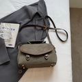 Olive green vintage crossbody bag with matte texture and top handle shown on a suit jacket - Green Without Pendant