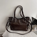 Dettaglio della pelle marrone scuro cerata con occhielli in metallo argento sulla borsa - caffè