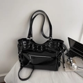 Dettaglio della borsa tote nera lucida vintage con occhielli in metallo e borchie stile punk - Nero