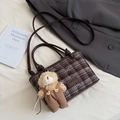 Detail of checkered crossbody bag with bow accent and brown teddy bear plush charm - Coffee With Pendant